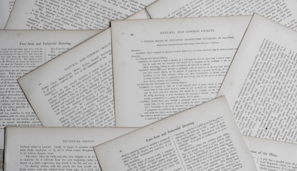 Multiple pages of printed text documents spread out, representing unstructured PDF content to be parsed